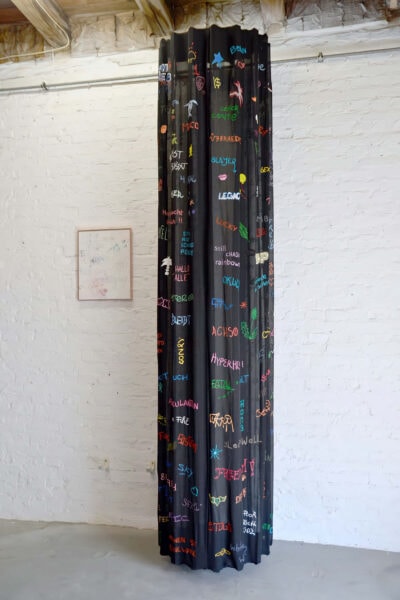 Painting of colored written words fragments on a black surface creating a column, by artist Patricia Sandonis