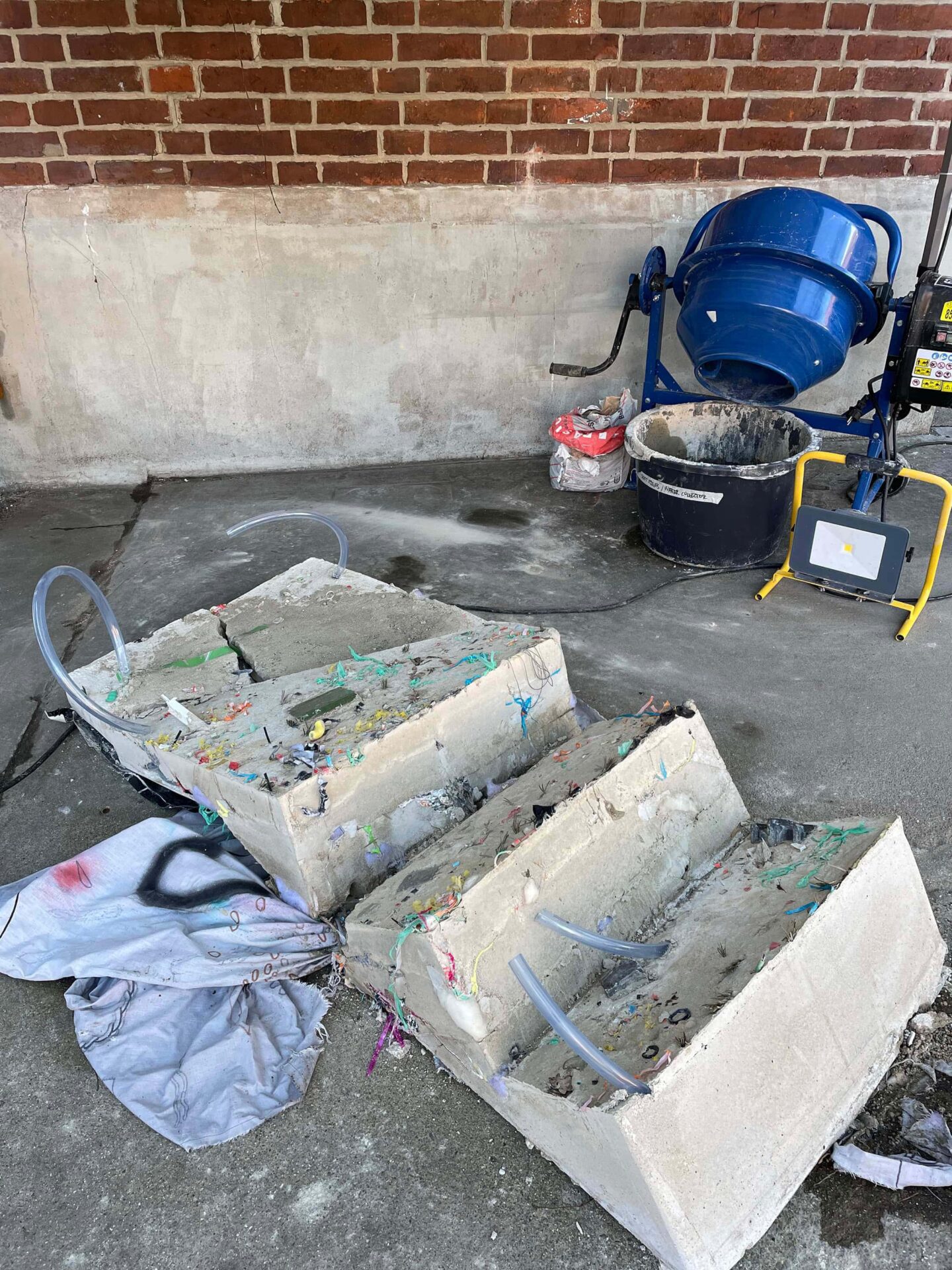 Sculptural art installation, broken stairs out of concrete, concrete mixer and painting on linen by artists Patricia Sandonis and Jelena Fuzinato