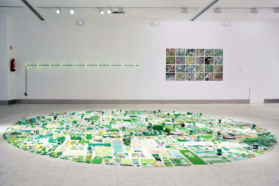 Patricia Sandonis art installation called The Berlin Circle, showing a circle of green plastic remnants, a green light installation and a series of photographs