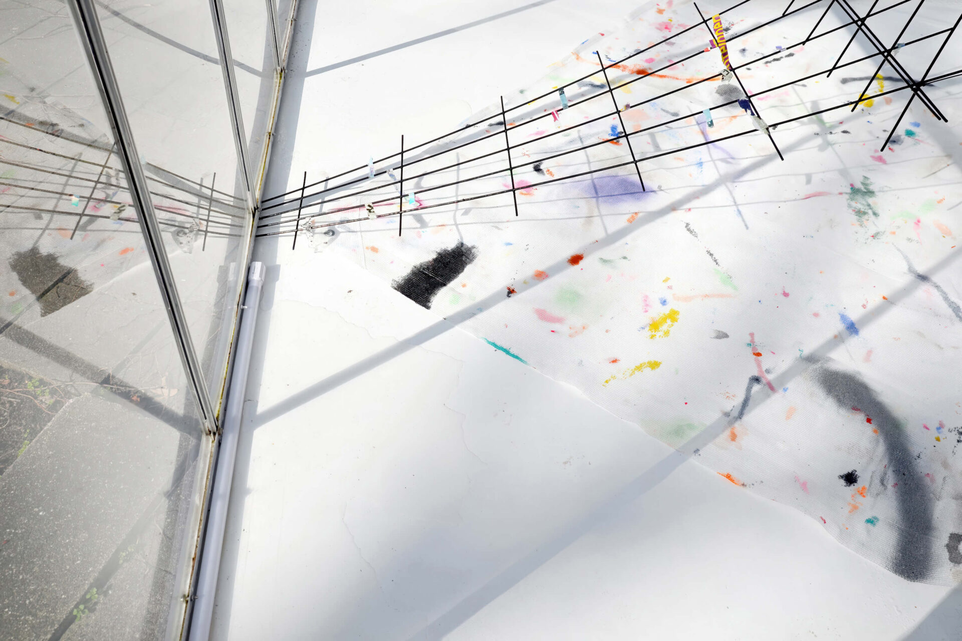 Fragments of colors and black lines on a white surface, detail of the art installation A Partition of the Sensible by Patricia Sandonis