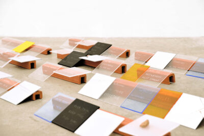 Art installation by artist Patricia Sandonis consisting of methacrylate pieces in different colors engraved with phrases