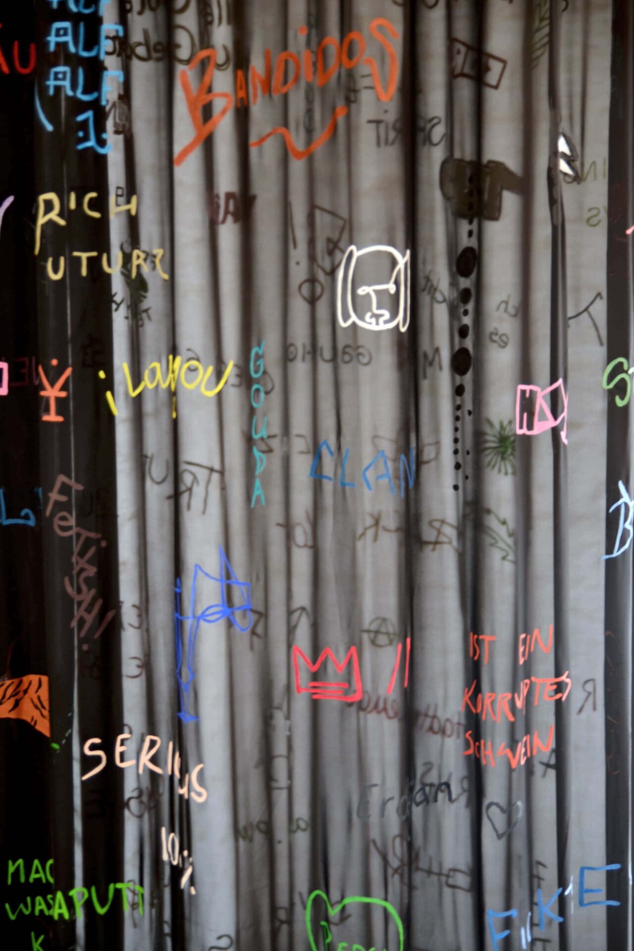 Different colored sentences written and painted on a semi-transparent black chiffon fabric, detail of an artwork by Patricia Sandonis