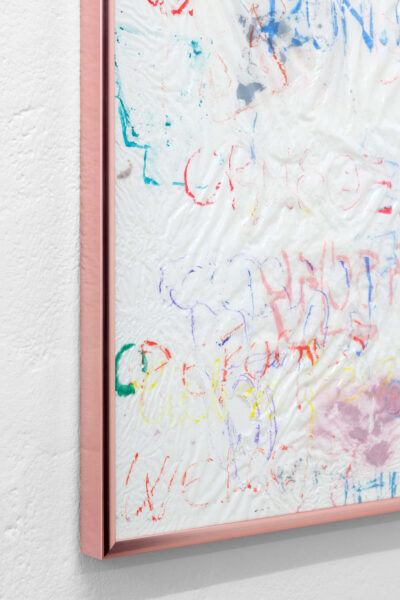 Detail of an artwork by Patricia Sandonis consisting of colored fragments painted on a white plastic bag and a pink frame