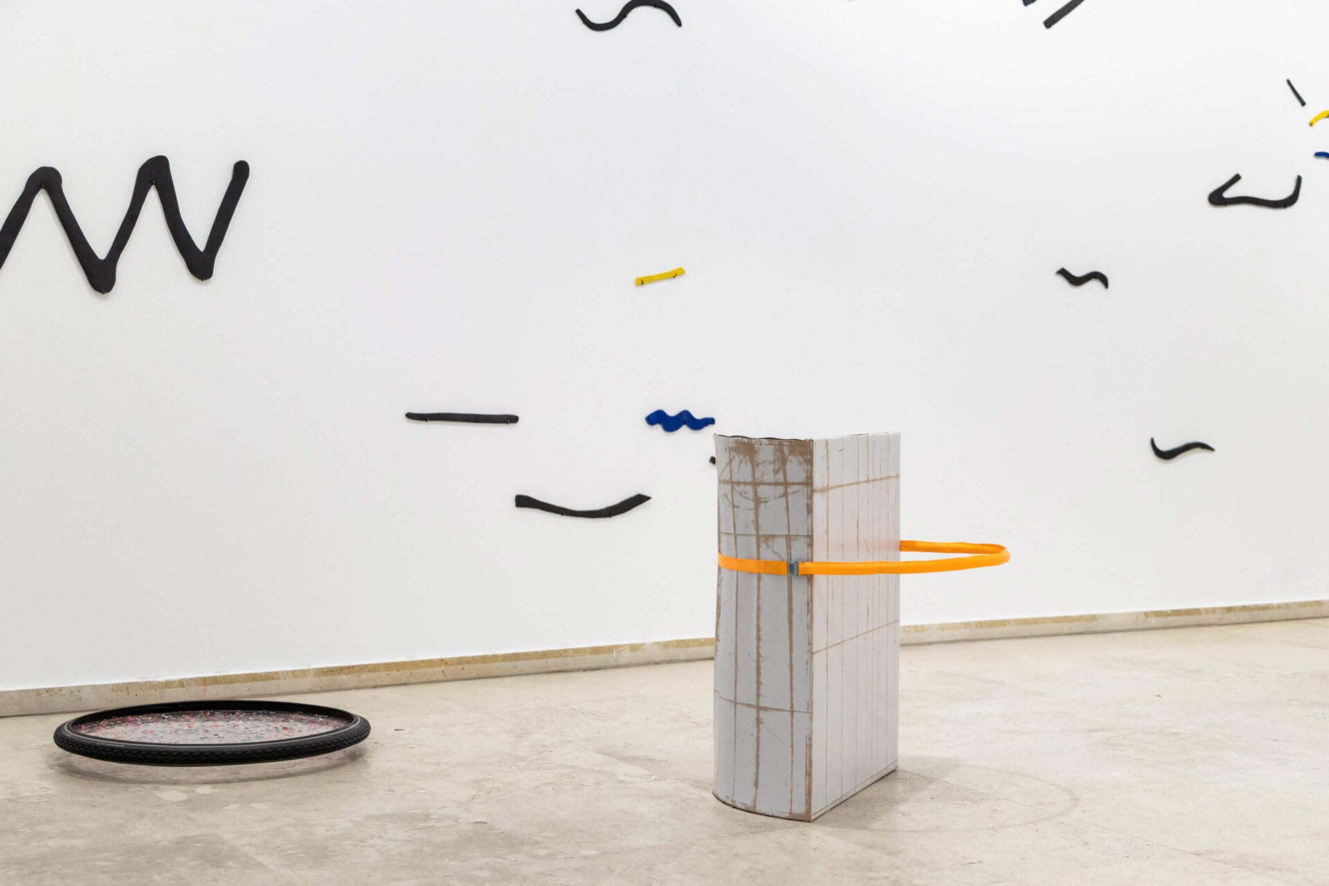 Contemporary art installation by Patricia Sandonis at Museo Patio Herreriano. Series of sculptures on a wall and on the floor made out of ceramic and plastic