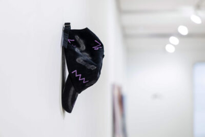 Intervened black cap by artist Patricia Sandonis shown in an art exhibition at Museo Patio Herreriano