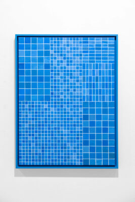 Blue oil painting on blue frame by conceptual artist Patricia Sandonis showing small shapes imitating the tiles from the facade of the Palace of Tears in Berlin