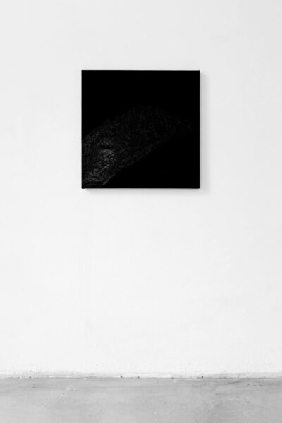 Black square painting hanging on a white wall by artist Patricia Sandonis
