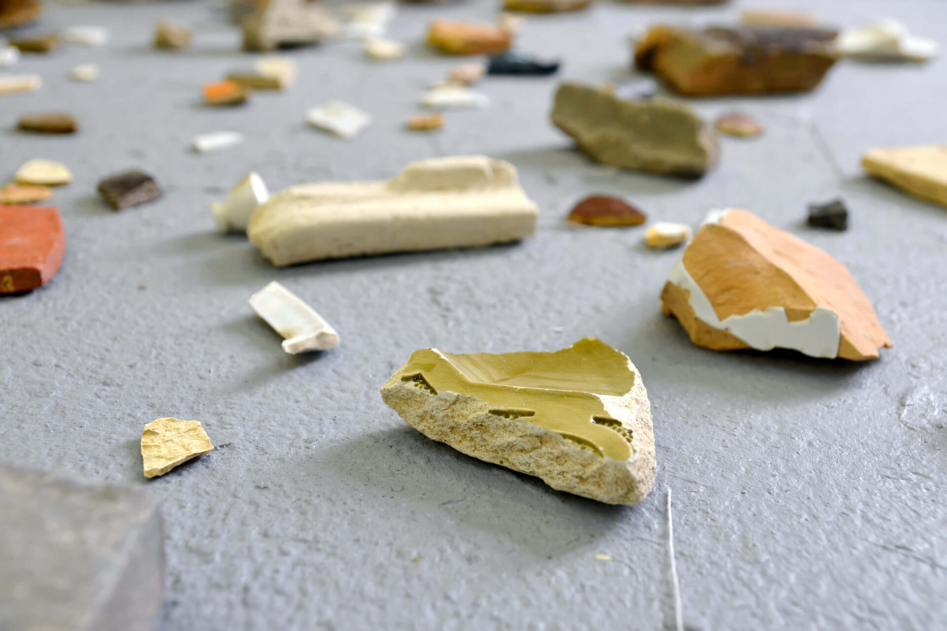 Found debris at Teufelsberg, Berlin and shown as fragments on the floor, an artwork by Patricia Sandonis called Monuments of my personal history