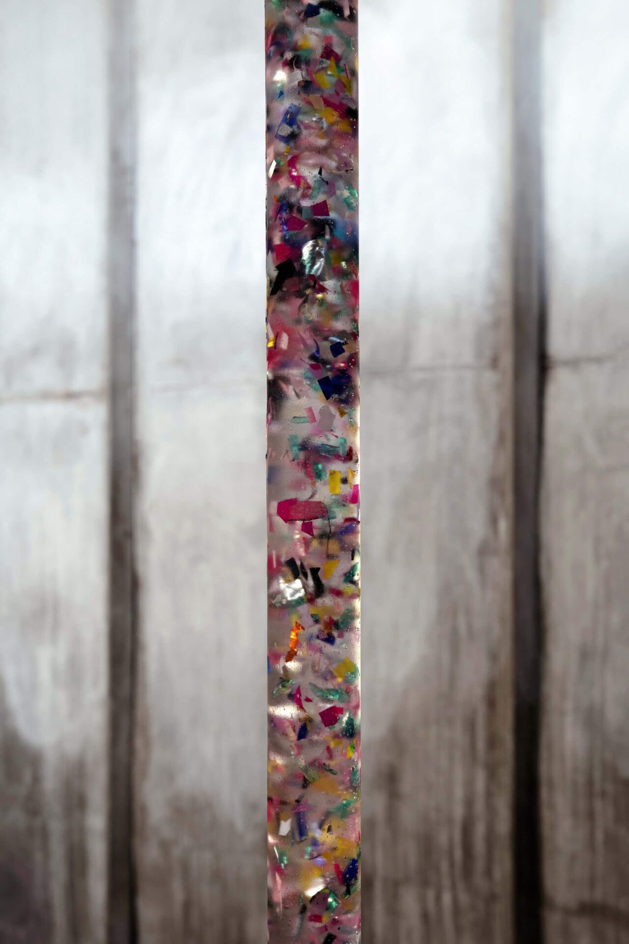 Sculpture of plastic and crystal clear with the form of a colored tube by artist Patricia Sandonis