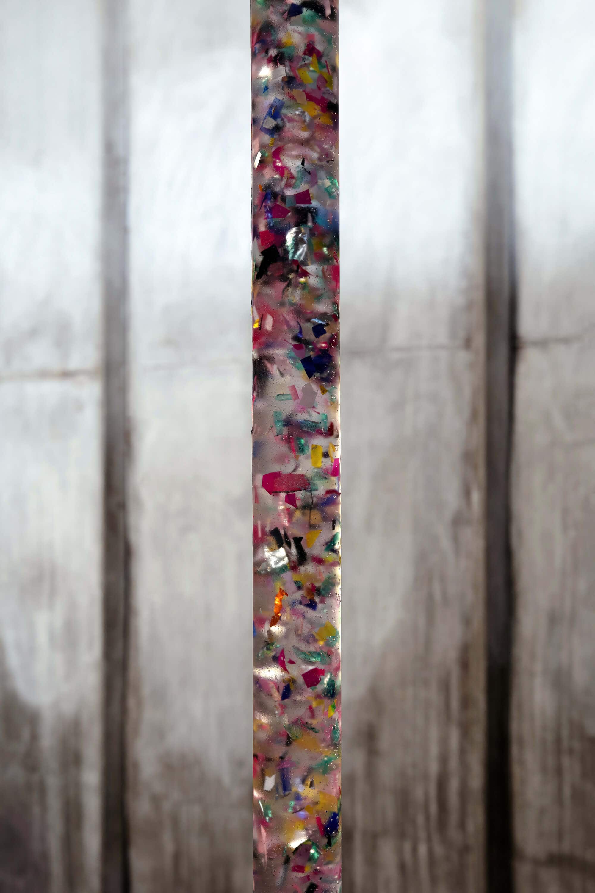 Sculpture of plastic and crystal clear with the form of a colored tube by artist Patricia Sandonis