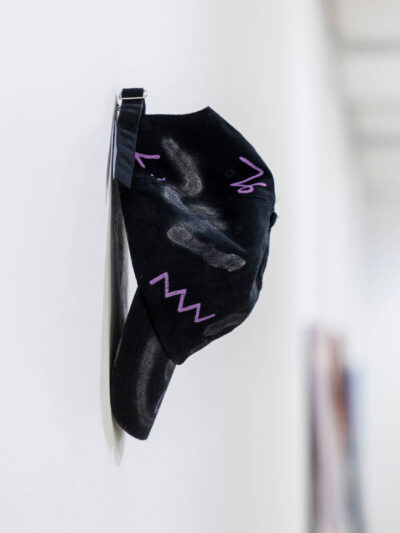 Intervened black cap by artist Patricia Sandonis shown in an art exhibition at Museo Patio Herreriano