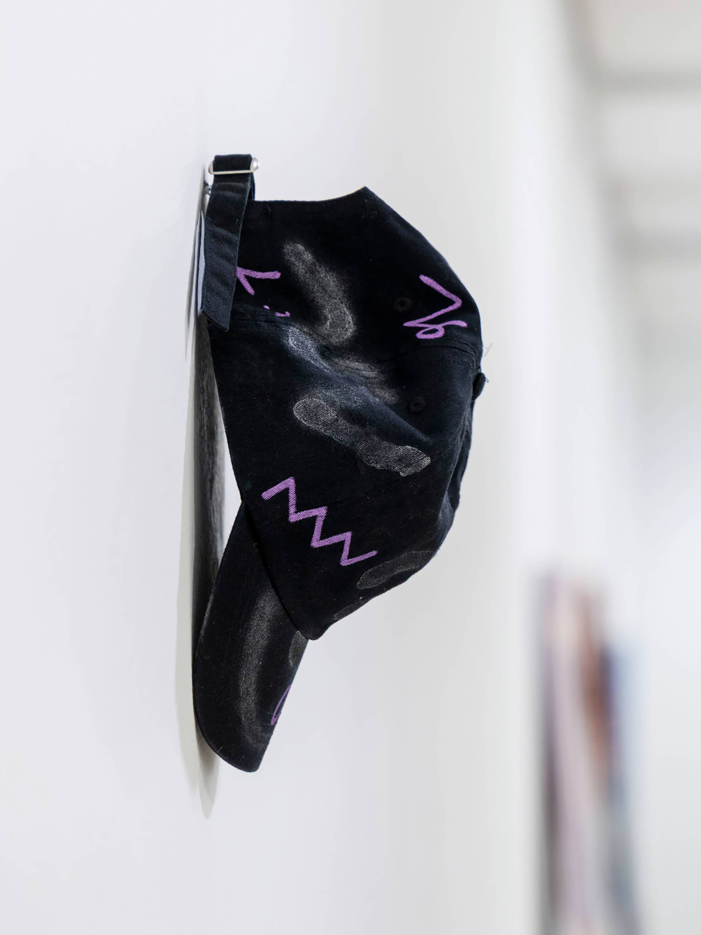 Intervened black cap by artist Patricia Sandonis shown in an art exhibition at Museo Patio Herreriano