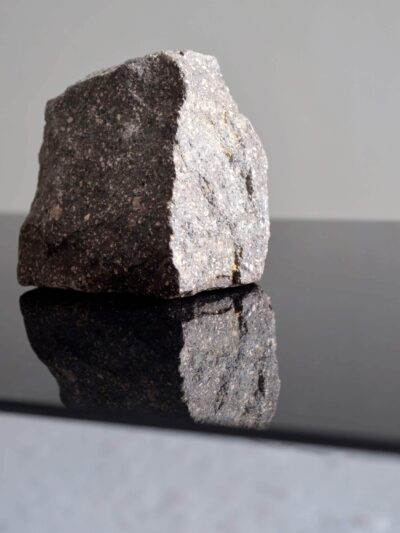 Stone on a black mirror crystal, a photography by artist Patricia Sandonis