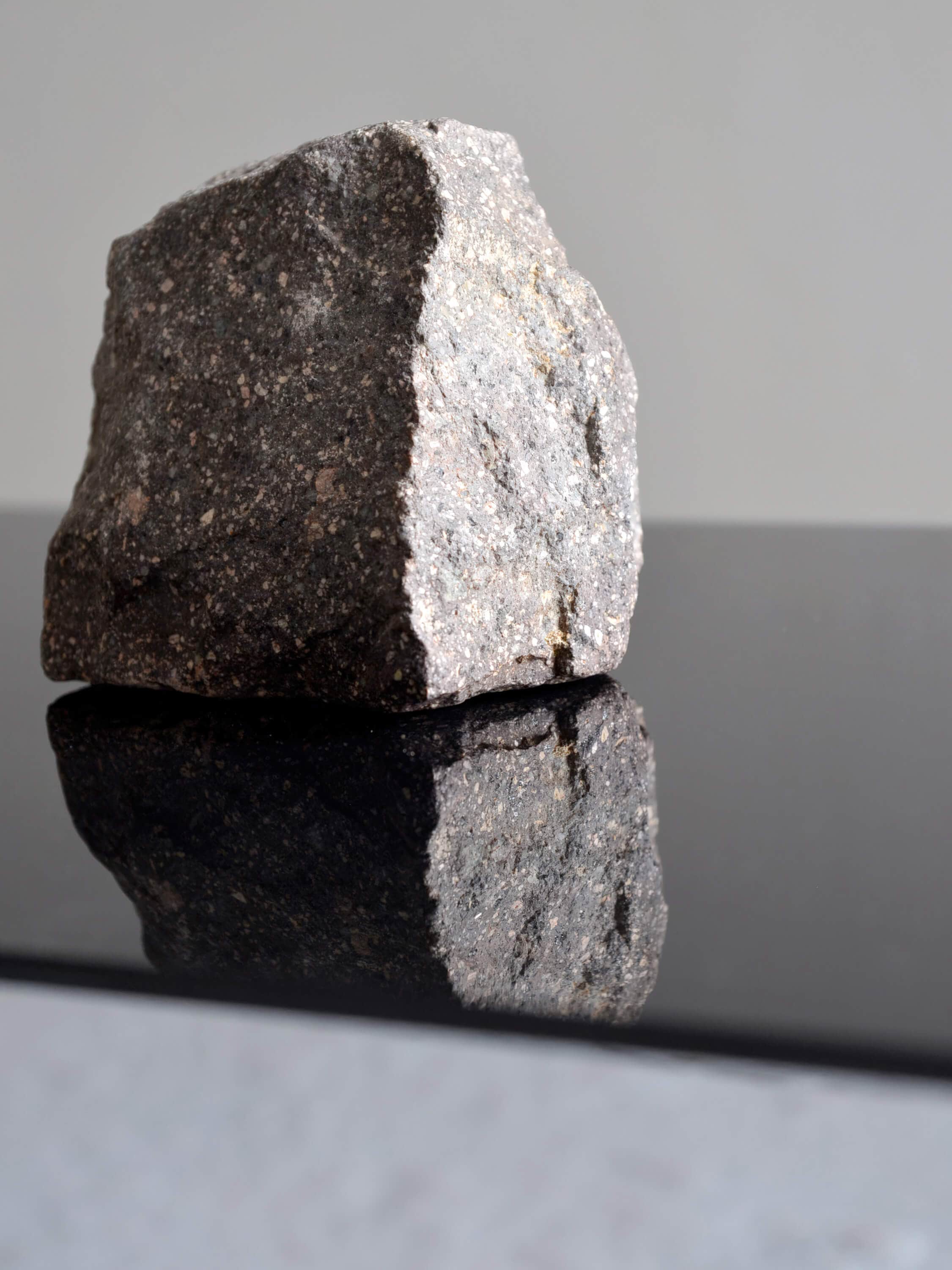 Stone on a black mirror crystal, a photography by artist Patricia Sandonis